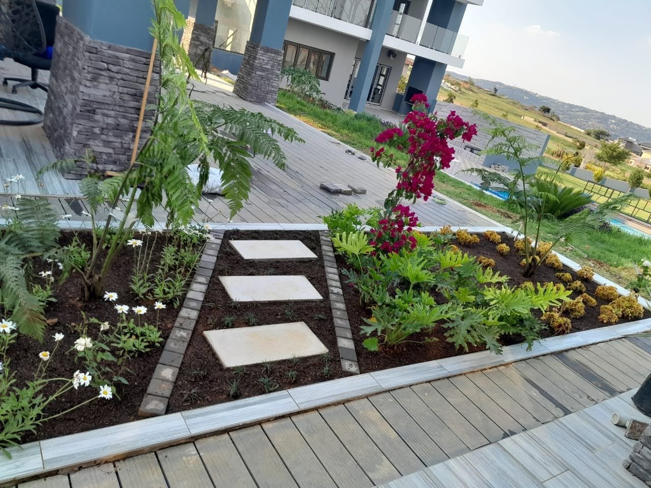 Designed flower bed with stepping stones and mixed planting