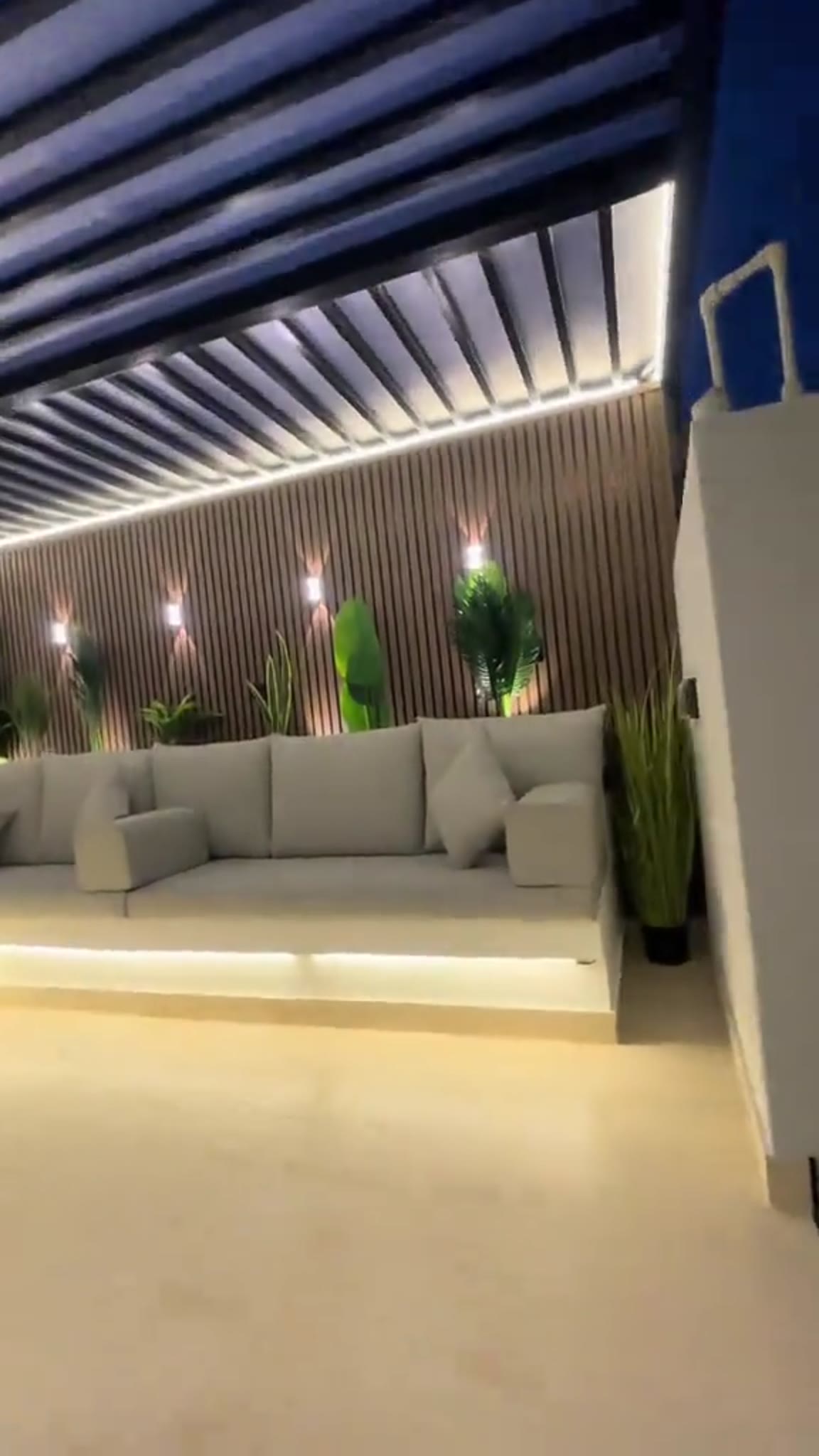 Steel frame outdoor patio lounge area with lighting and planting