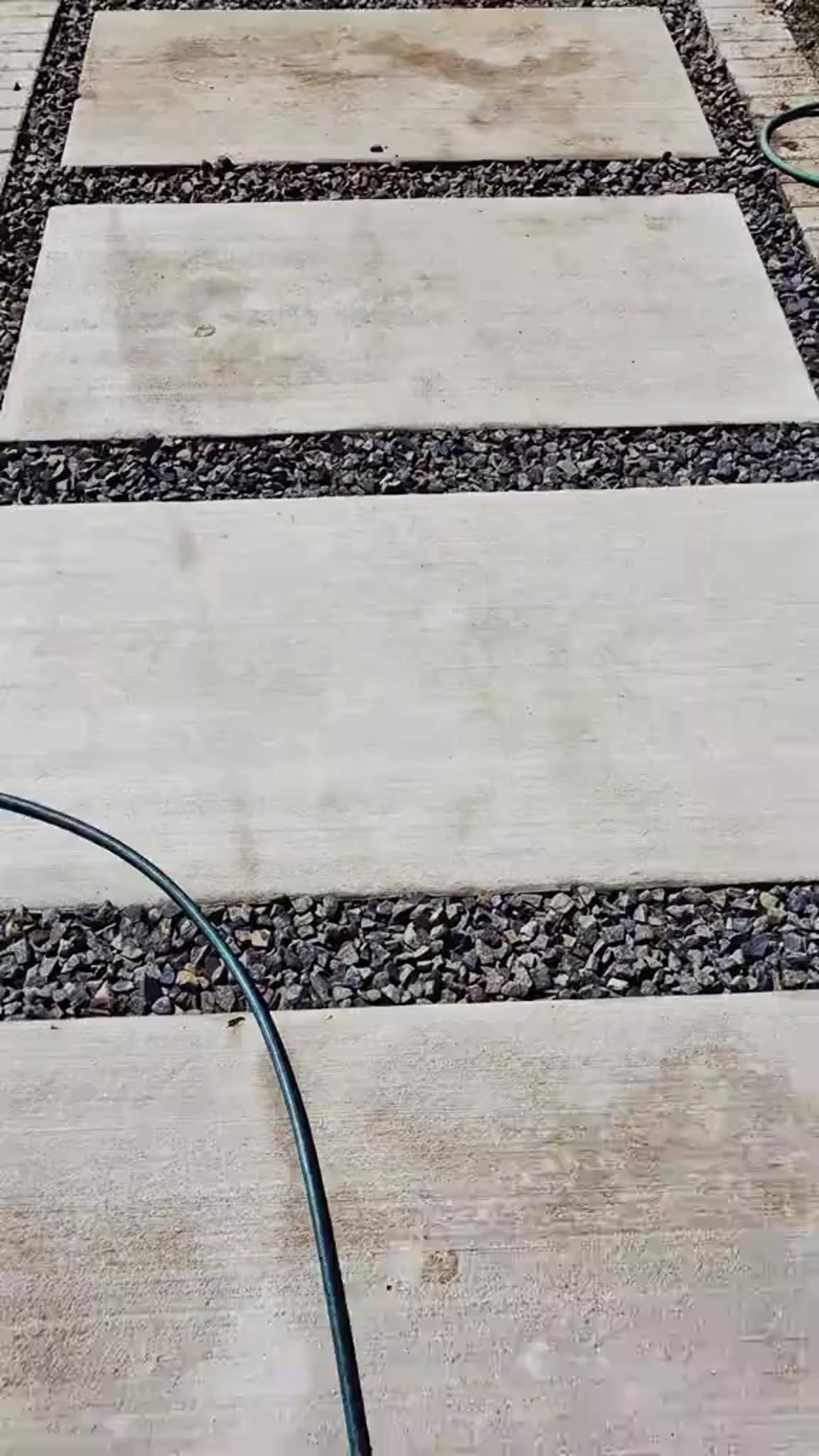 Concrete slab pathway with black stone infill