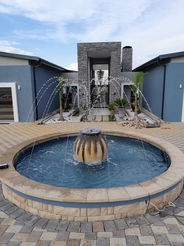 Circular water feature and fountain in a paved courtyard