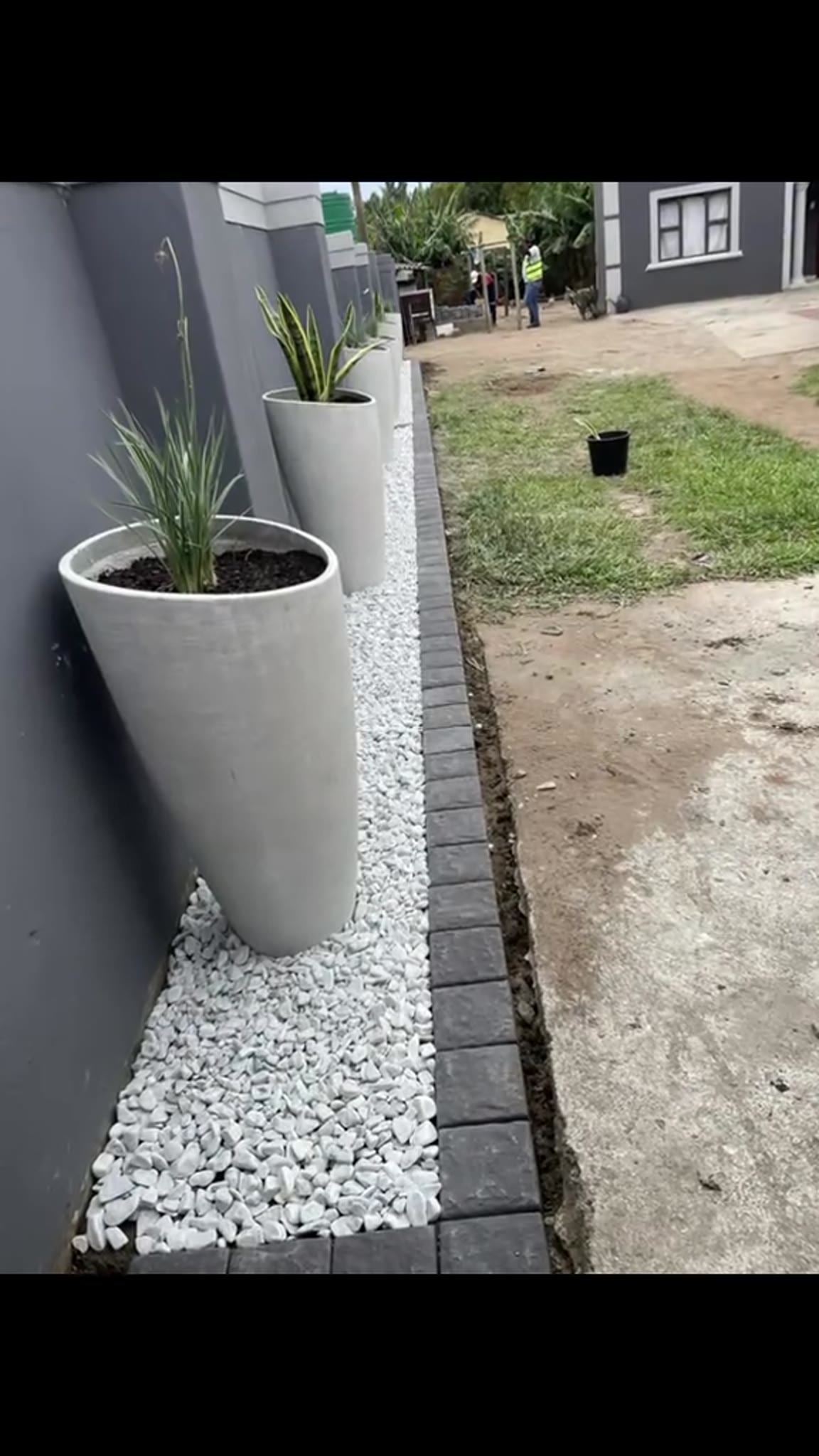 White stone garden bed with tall planters